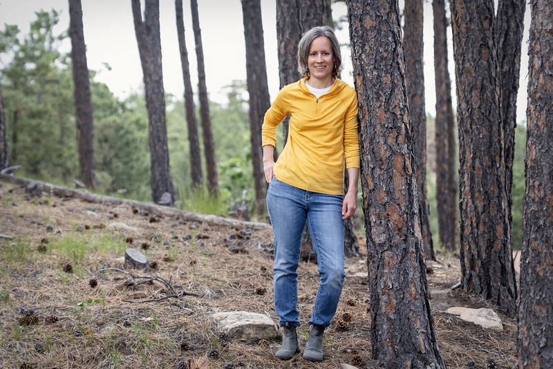 Sarah Swantner standing among ponderosa pines in the Black Hills
