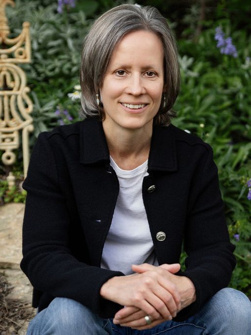Sarah Swantner seated in a garden of purple wildflowers