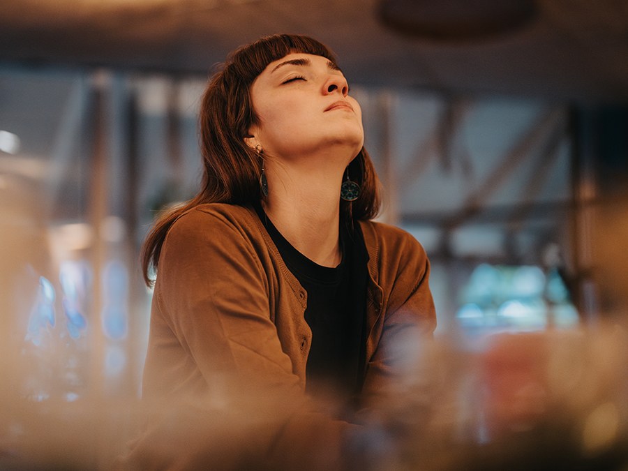A woman with her eyes closed and her face lifted, at ease